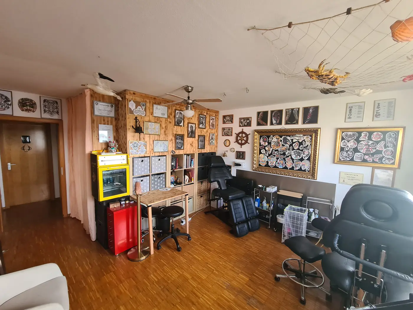 Blick ins Studio mit Tattoo-Liegen und Flash-Rahmen an der Wand