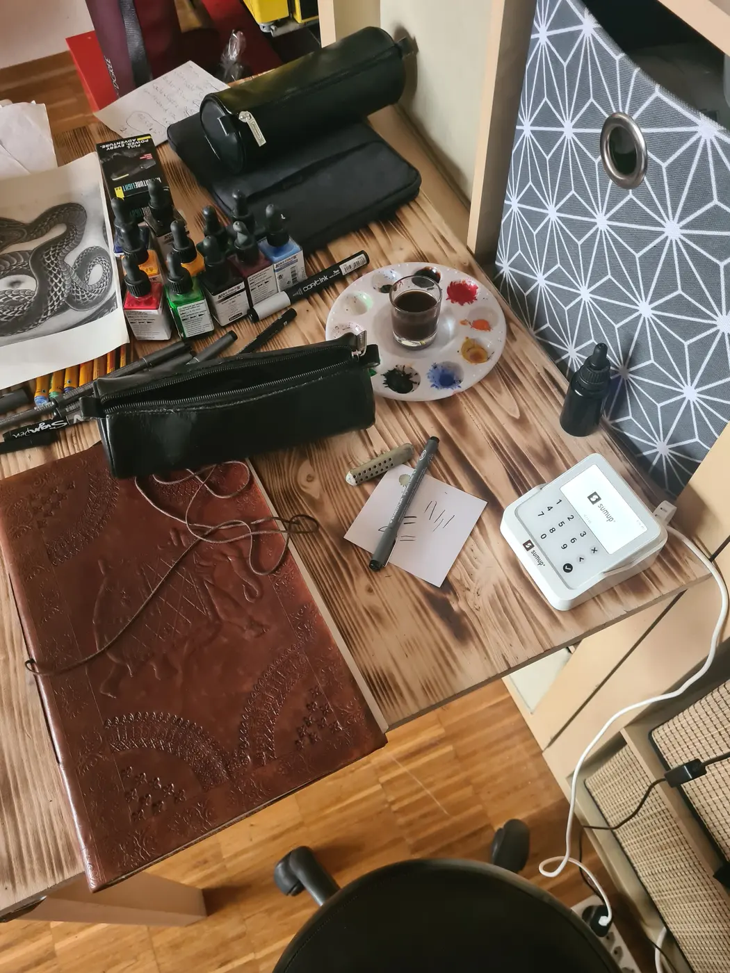 Zeichentisch mit Skizzenbuch und Farben